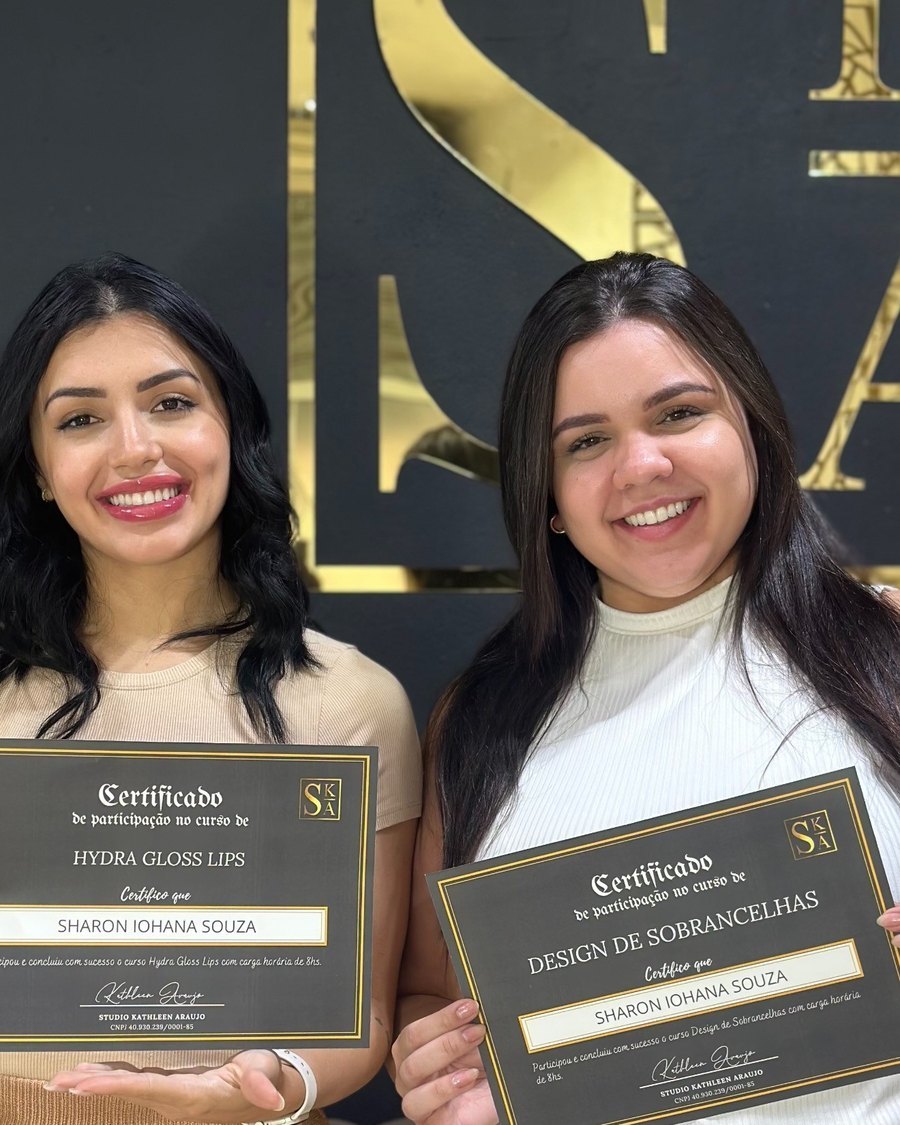 Alunas formadas com os certificados em frente ao letreiro do studio