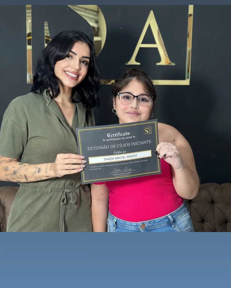 Aluna formada segurando o certificado no Studio Kathleen Araújo